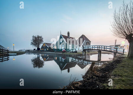 Beaucoutif olandese di tipiche case di legno architettura specchiata sul tranquillo canale di Zaanse Schans situato a nord di Amsterdam, Paesi Bassi Foto Stock