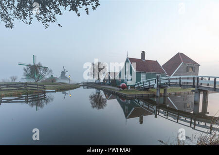 Beaucoutif olandese di tipiche case di legno architettura specchiata sul tranquillo canale di Zaanse Schans situato a nord di Amsterdam, Paesi Bassi Foto Stock