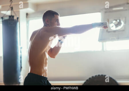 Boxer maschio durante il pugilato esercizio facendo colpo diretto. sport concept Foto Stock