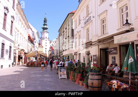 Pedoni e caffetterie lungo Venturska Michalska con vista di Michael's Gate nella città vecchia di Bratislava, Slovacchia Foto Stock