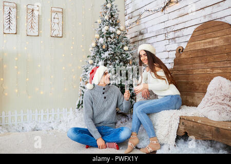 Felice coppia giovane indossando cappelli di Babbo Natale il divertimento a Natale. Foto Stock