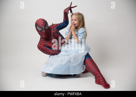 Israele, Tel Aviv Ottobre 14, 2018. La spiderman è in possesso di una bambina tra le sue braccia. Un uomo in una tuta di Spiderman è venuto a congratularsi con il bambino per il suo compleanno. Spiderman Costume noleggio. Foto Stock