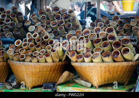 Snack dolce stile tailandese Khao Lam o glutinoso riso imbevuto di latte di cocco e cotto arrosto nel gambo di bambù in vendita presso il negozio locale a Ang Sila se Foto Stock