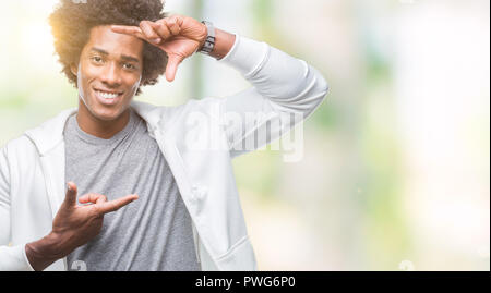 Afro American uomo felpa da indossare sopra lo sfondo isolato sorridente rendendo il telaio con le mani e le dita con la faccia felice. La creatività e la fotografia Foto Stock