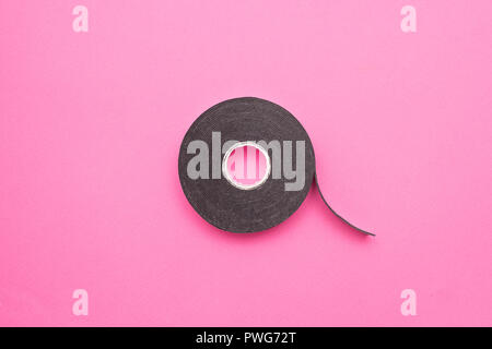 Bobina di nastro biadesivo su un sfondo rosa, close-up, nastro biadesivo nastro Scotch Foto Stock