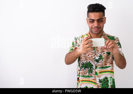 Giovani indiani tourist uomo che indossa camicia hawaiana contro white ba Foto Stock