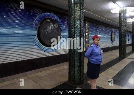 Un personale di sicurezza guardia accanto a pitture murali del periodo sovietico dedicato alla sovietica cosmonauti Kosmonavtlar alla stazione della metropolitana di Tashkent Metro in Uzbekistan. La metropolitana di Tashkent costruito nella ex URSS è solo uno dei due sistemi di metropolitana attualmente operativo in Asia centrale e le sue stazioni sono tra i più ornato nel mondo. Foto Stock