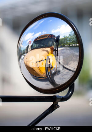 Tradizionale American School bus relected sul suo specchio convesso Foto Stock