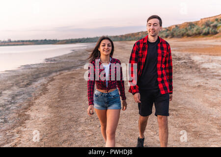 Oung giovane sulla spiaggia camminando insieme Foto Stock