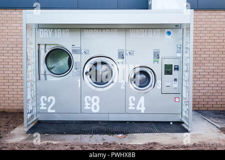 A Gettone lavatrice in città all'aperto per uso pubblico a gettone Foto Stock