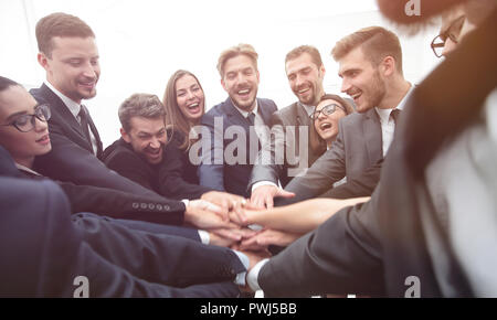 Un folto gruppo di persone di affari in piedi con le mani piegate insieme Foto Stock