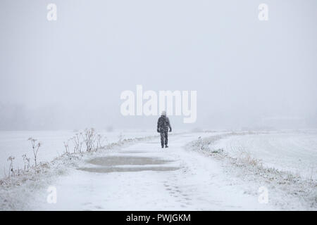 Il camminatore solitario sul percorso in neve pesante Foto Stock
