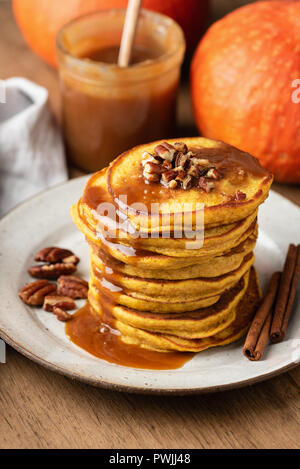 La zucca spice pancake con salsa di caramello e i dadi su una piastra, primo piano, il fuoco selettivo. Autunno comfort food Foto Stock