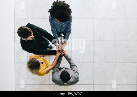 Vista dall'alto del team aziendale che mette le mani insieme. professionisti che mostrano lavoro di squadra e unità. Foto Stock