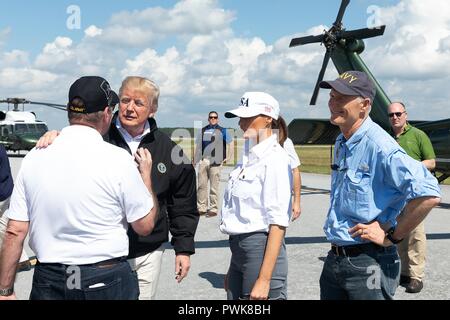 Panama City, Florida, Stati Uniti d'America. 15 ott 2018. U.S presidente Donald Trump parla con un residente locale dopo touring danni dopo il passaggio dell uragano Michael al nord-ovest spiagge aeroporto internazionale 15 ottobre 2018 nella città di Panama, Florida. In piedi con il presidente da sinistra a destra sono residente locale, presidente Donald Trump, First Lady Melania Trump e Florida Gov. Rick Scott. Credito: Planetpix/Alamy Live News Foto Stock