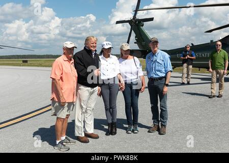 Panama City, Florida, Stati Uniti d'America. 15 ott 2018. U.S presidente Donald Trump si distingue per una foto con un residente locale a seguito di una visita dei danni dopo il passaggio dell uragano Michael al nord-ovest spiagge aeroporto internazionale 15 ottobre 2018 nella città di Panama, Florida. In piedi con il presidente da sinistra a destra sono residente locale, presidente Donald Trump, First Lady Melania Trump, First Lady della Florida Ann Scott e Florida Gov. Rick Scott. Credito: Planetpix/Alamy Live News Foto Stock