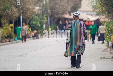 Kashgar, della Cina di Xinjiang Uygur Regione autonoma. Xvi oct, 2018. Un uomo anziano vestito in costume tradizionale passeggiate su una strada nella città di Kashgar, a nord-ovest della Cina di Xinjiang Uygur Regione autonoma, 16 ottobre 2018. L'antica oasi città di Kashgar, nella parte più occidentale della Cina vicino al confine con il Kirghizistan, il Tagikistan, Afghanistan e Pakistan, è stato un importante luogo di sosta post sull'originale Silk Road ed è stato rivitalizzato come una vivace mozzo del business e delle diverse culture. Credito: Hu Huhu/Xinhua/Alamy Live News Foto Stock