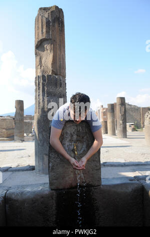 Ragazzo adolescente avente un drink in Pompei, Italia Foto Stock