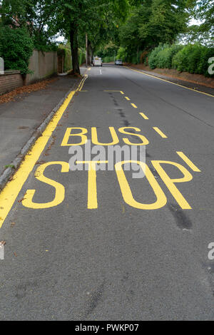 Fermata bus sign in vernice gialla sulla superficie stradale Foto Stock