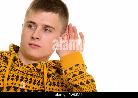 Curioso uomo caucasico coppettazione orecchio e ascolta Foto Stock