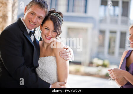 Sposa e lo sposo in piedi sul ponte con damigella Foto Stock