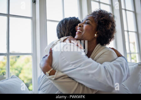 Alleviato donna matura abbracciando il suo medico di famiglia. Foto Stock