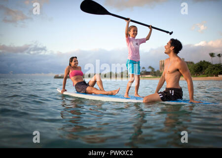 Madre, padre e figlia sulla tavola da surf Foto Stock