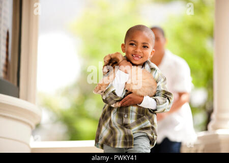 Ritratto di giovane ragazzo tenendo un cucciolo. Foto Stock