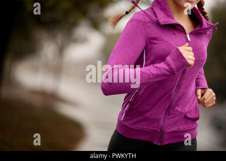 Young woman jogging on a residential street. Foto Stock