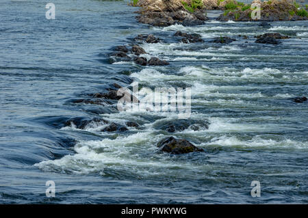 La bellezza di acqua che scorre sopra e intorno alle rocce in un fiume. Foto Stock