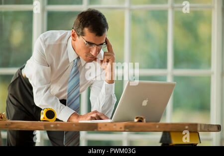 Adulto medio imprenditore lavora su un computer portatile. Foto Stock
