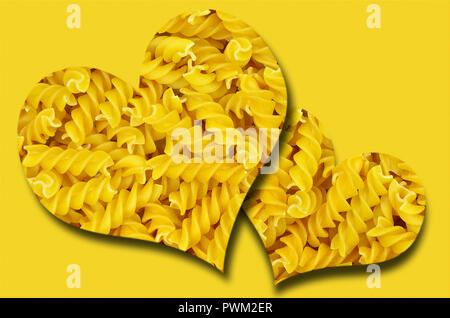 Due cuori con pasta su sfondo giallo, vicino, frame completo Foto Stock