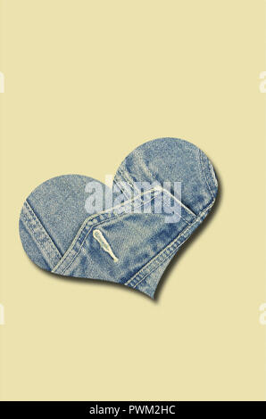 Jeans cuore isolato su sfondo beige, close up, verticale Foto Stock