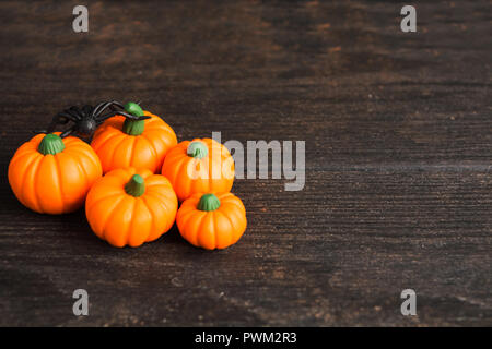 Cinque orange fake zucche con il ragno nero sul tavolo di Legno, Decorazione Halloween Foto Stock