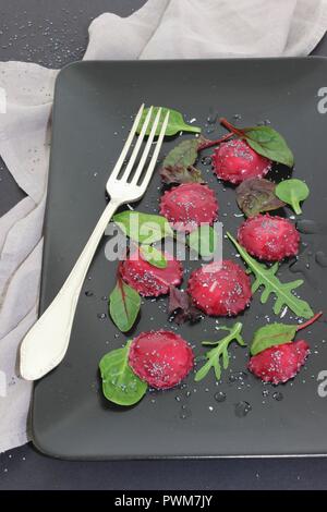 Ravioli di barbabietola con insalata mista lascia Foto Stock