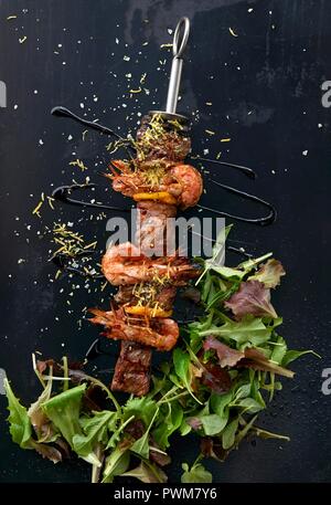 Carni bovine e spiedini di gamberi con insalata Foto Stock