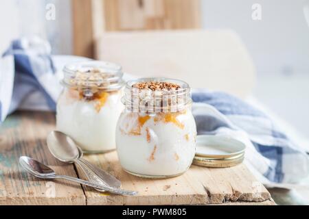 Yogurt con pezzi di arancio e noci tritate Foto Stock