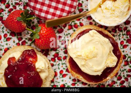 Un cornetto diviso a metà e rabboccato con clotted cream e confettura di fragole Foto Stock