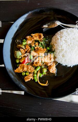 Pollo al curry con basilico tailandese, melanzane e fagioli con riso Foto Stock