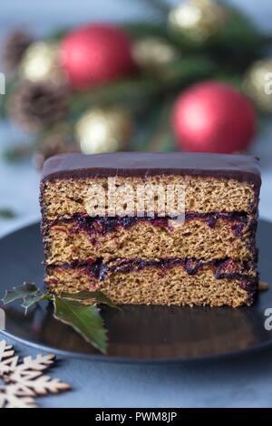 Fetta di una torta di pan di zenzero con marmellata di prugne e ganache al cioccolato Foto Stock