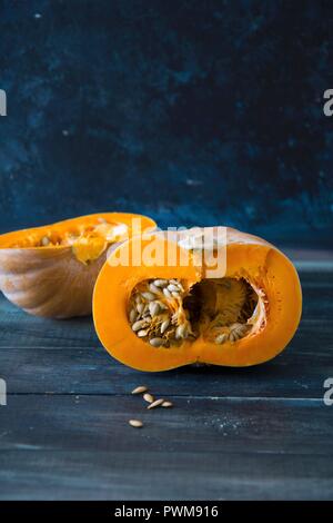 Una zucca dimezzata su uno sfondo di legno Foto Stock