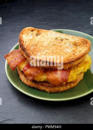 Un sandwich tostato con pancetta e uova per colazione (USA) Foto Stock