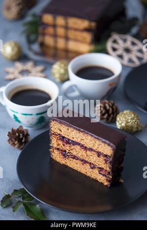 Fetta di un tradizionale polacco gingerbread torta con marmellata di prugne e ganache al cioccolato Foto Stock