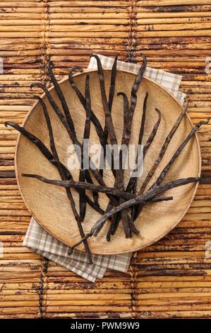 Baccelli di vaniglia sul piatto di legno Foto Stock