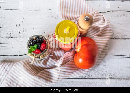 Fredda zuppa di pomodoro in un vaso accanto al muesli con un vaso di frutti di bosco (visto da sopra) Foto Stock