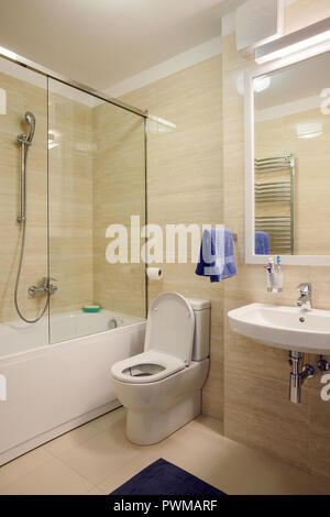 Interno di un piccolo bagno con wc in ceramica su pareti bianche in  appartamento vicino al cestino di rattan Foto stock - Alamy