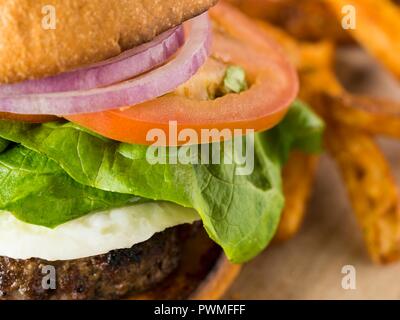 Un close-up di pomodoro, cipolla e lattuga in hamburger Foto Stock