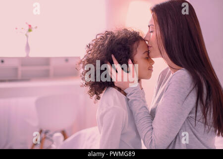 Piacevole parentesi ragazza ricevere un bacio da sua madre Foto Stock
