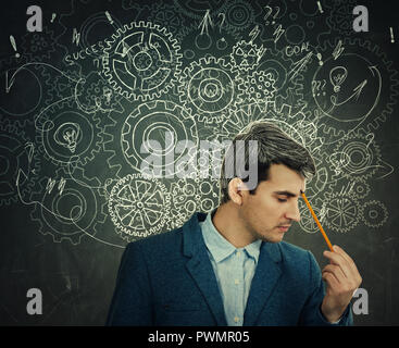 Difficile pensare grave uomo sulla lavagna sfondo cervello ingranaggio di frecce e pasticcio come pensieri. Concetto per mentale, lo sviluppo psicologico. Foto Stock