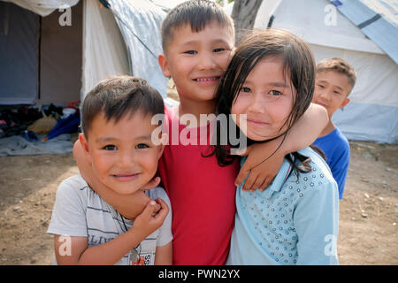 I bambini rifugiati dalla Siria e Afghanistan davanti le tende vicino al camp MORIA CAMP per i rifugiati. Isola di Lesbo, Grecia, Maggio 2018 - Flüchtlingskinder aus Syrien und Afghanistan Vor den Zelten neben dem Lager MORIA CAMP für Flüchtlinge. Insel Lesbo, Griechenland, Mai 2018 Foto Stock